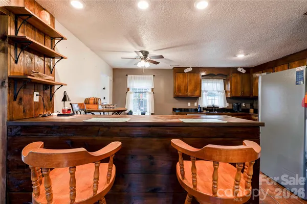 a kitchen with stainless steel appliances granite countertop a chairs a sink and a stove