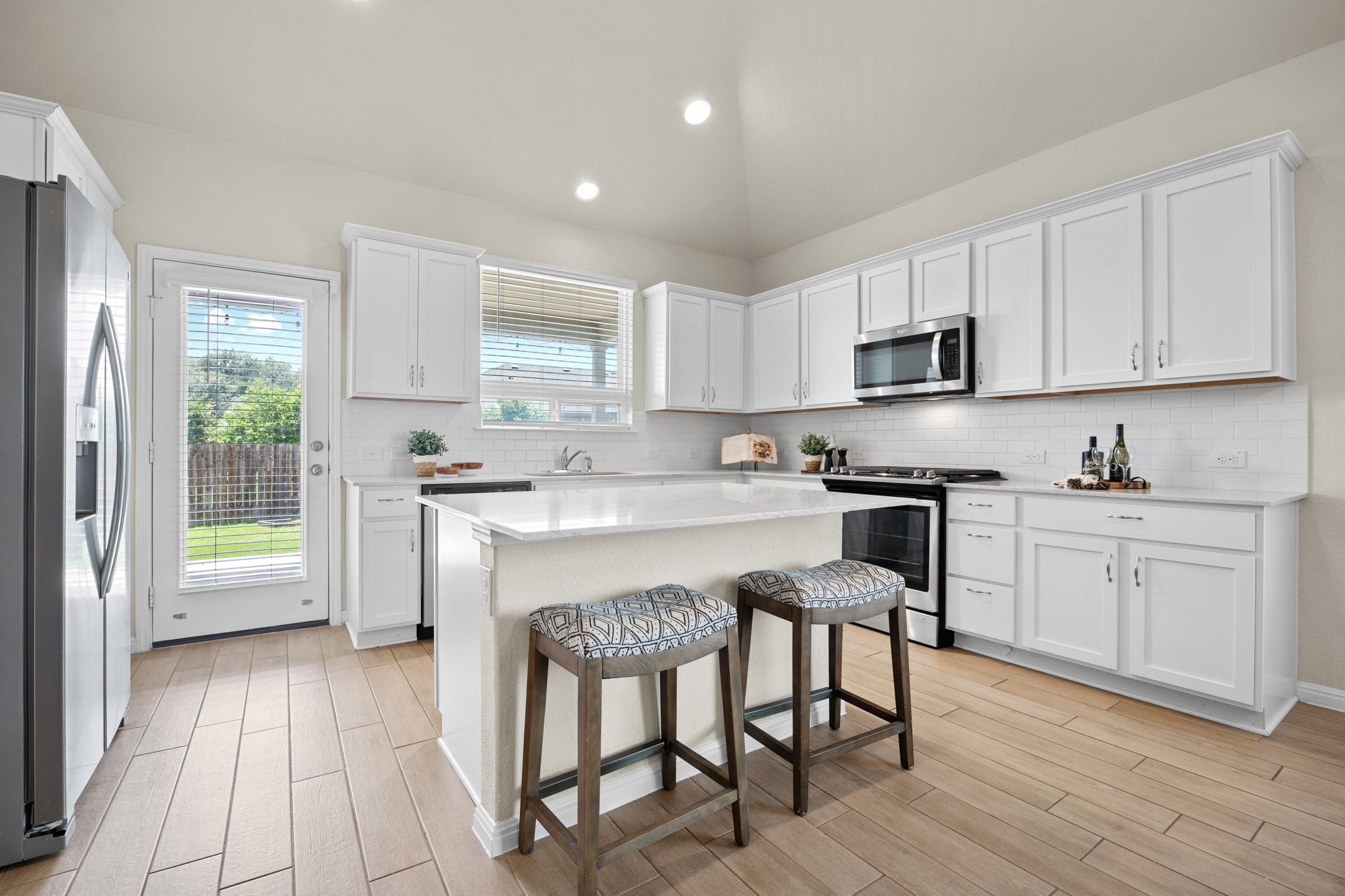 2413 Starhill Ranch Street Georgetown, TX 78628 - Photo 16 of 40 a kitchen with a sink cabinets and wooden floor