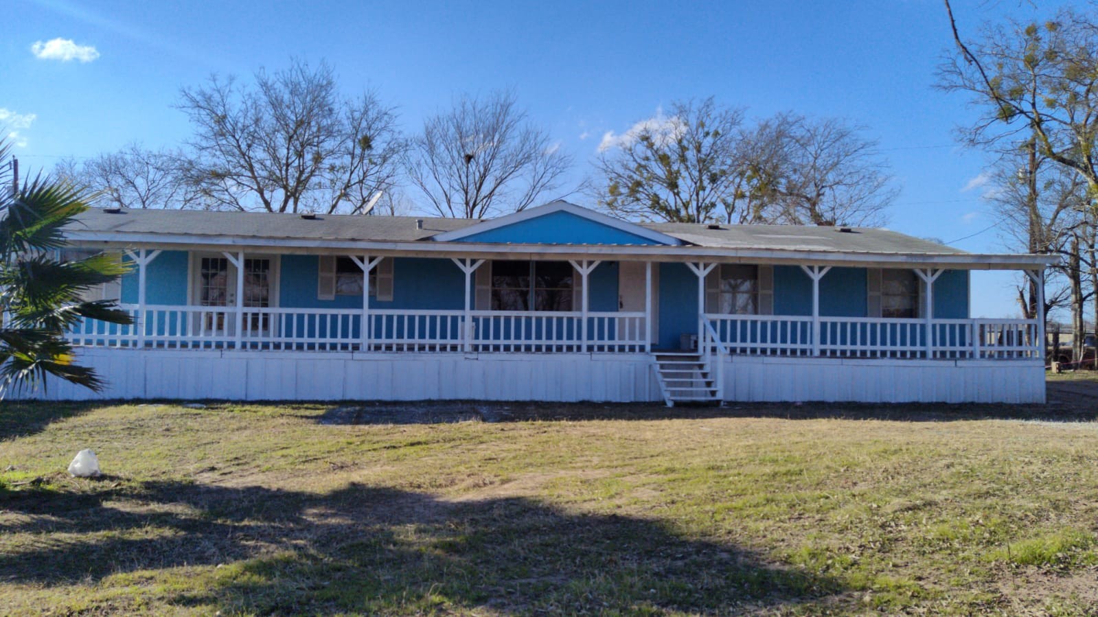 a view of a house with a small yard and wooden fence