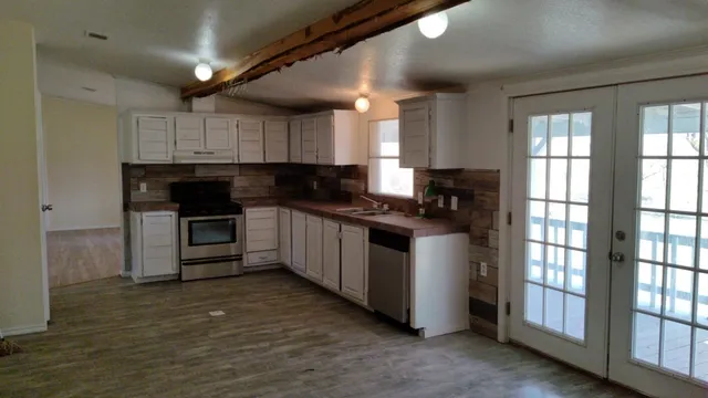 a kitchen with granite countertop a stove a sink and a refrigerator