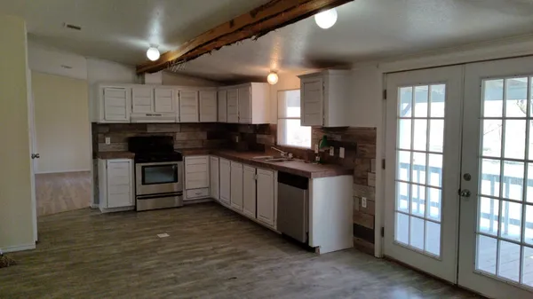 a kitchen with granite countertop a stove a sink and a refrigerator
