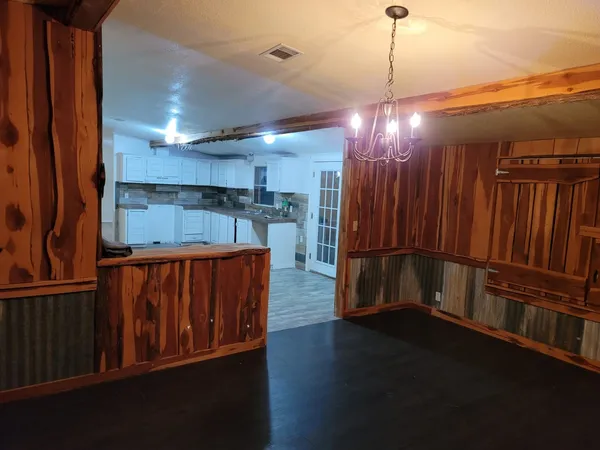 a kitchen with stainless steel appliances wooden floors wooden cabinets a refrigerator and a sink