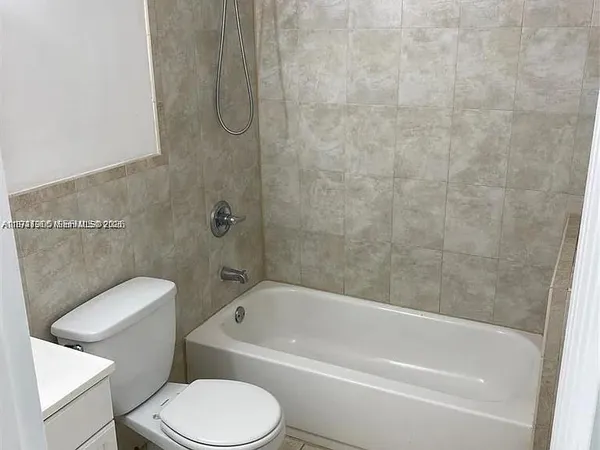 a white toilet and tub sitting next to a bathroom sink