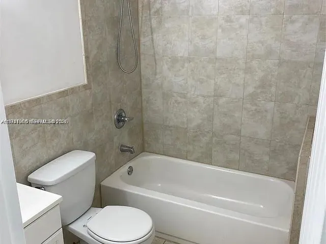 a white toilet and tub sitting next to a bathroom sink