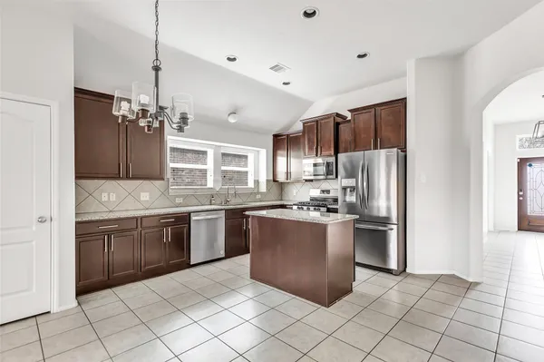 a kitchen with granite countertop a sink stainless steel appliances and cabinets