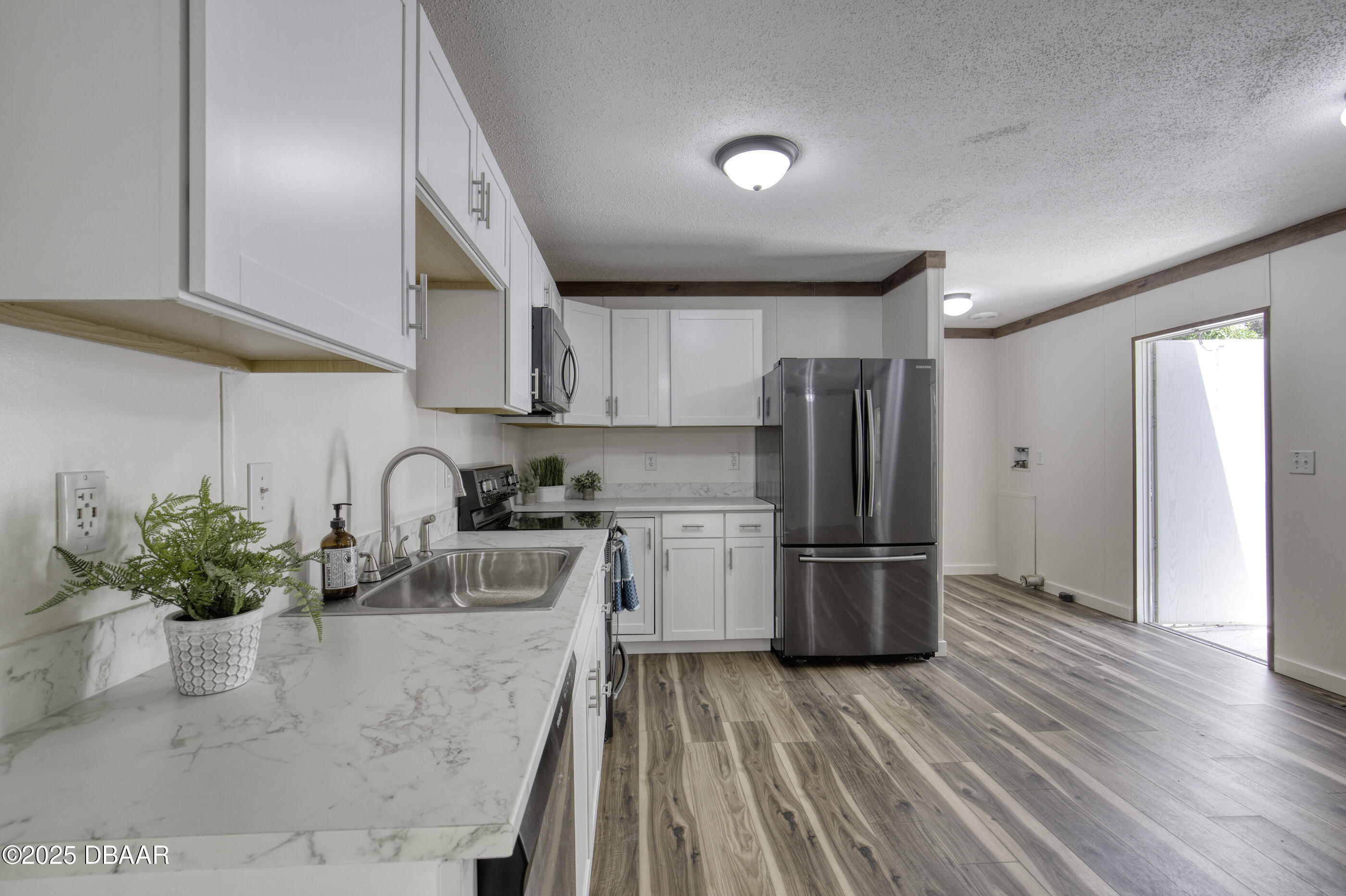 2089 Guava Lane Bunnell, FL 32110 - Photo 18 of 58 a kitchen with a refrigerator sink and wooden floor