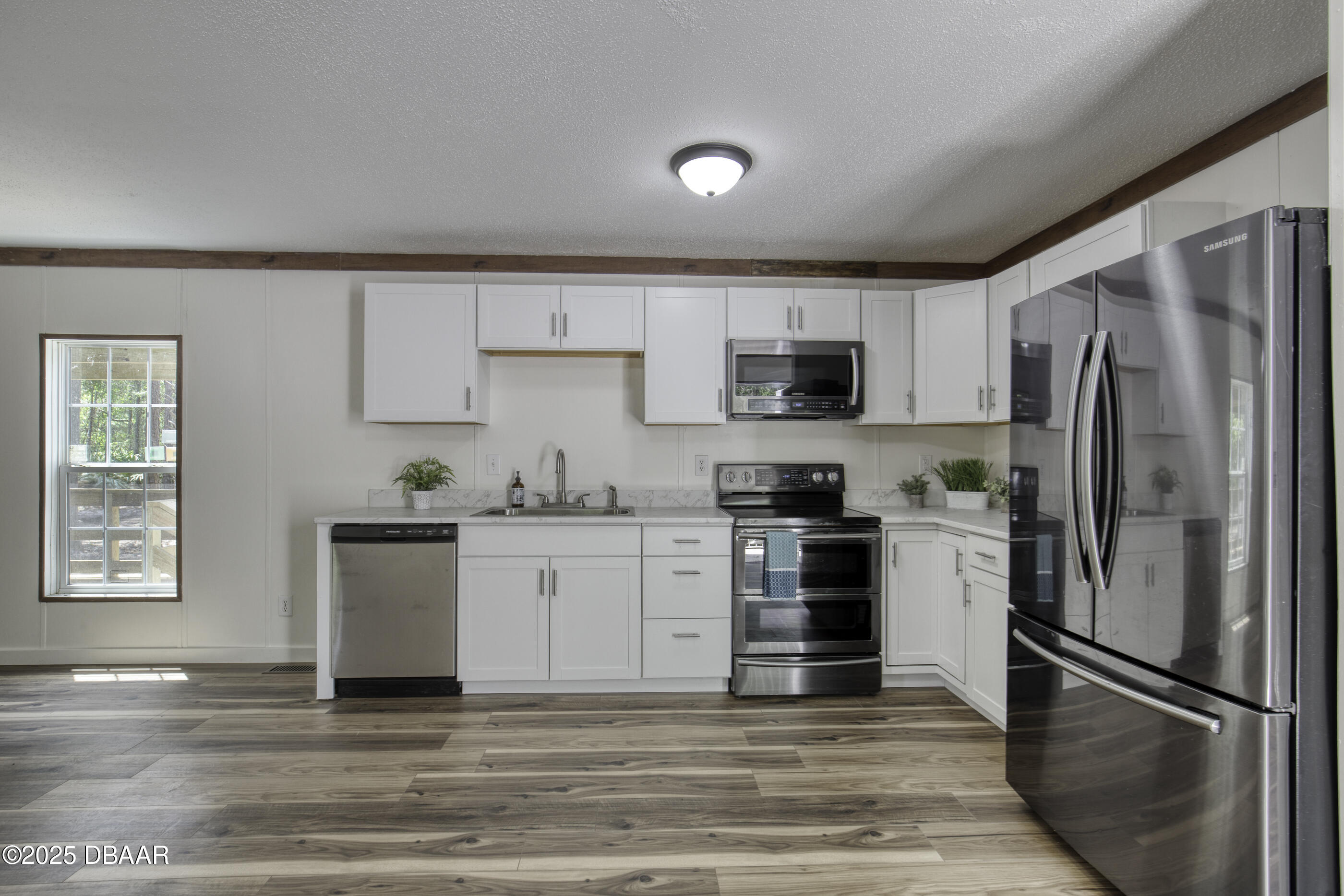2089 Guava Lane Bunnell, FL 32110 - Photo 19 of 58 a kitchen with granite countertop a refrigerator stove and microwave