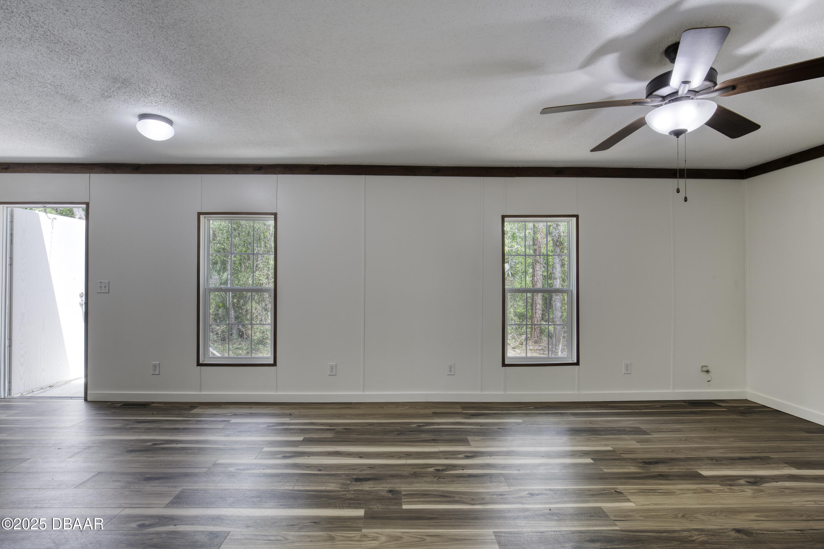 2089 Guava Lane Bunnell, FL 32110 - Photo 22 of 58 an empty room with wooden floor chandelier and windows
