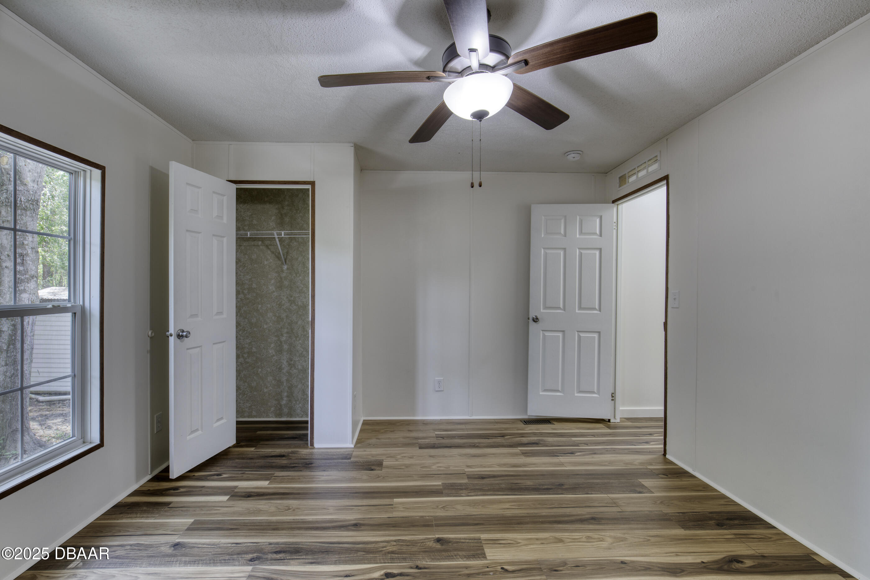 2089 Guava Lane Bunnell, FL 32110 - Photo 34 of 58 an empty room with wooden floor fan and windows