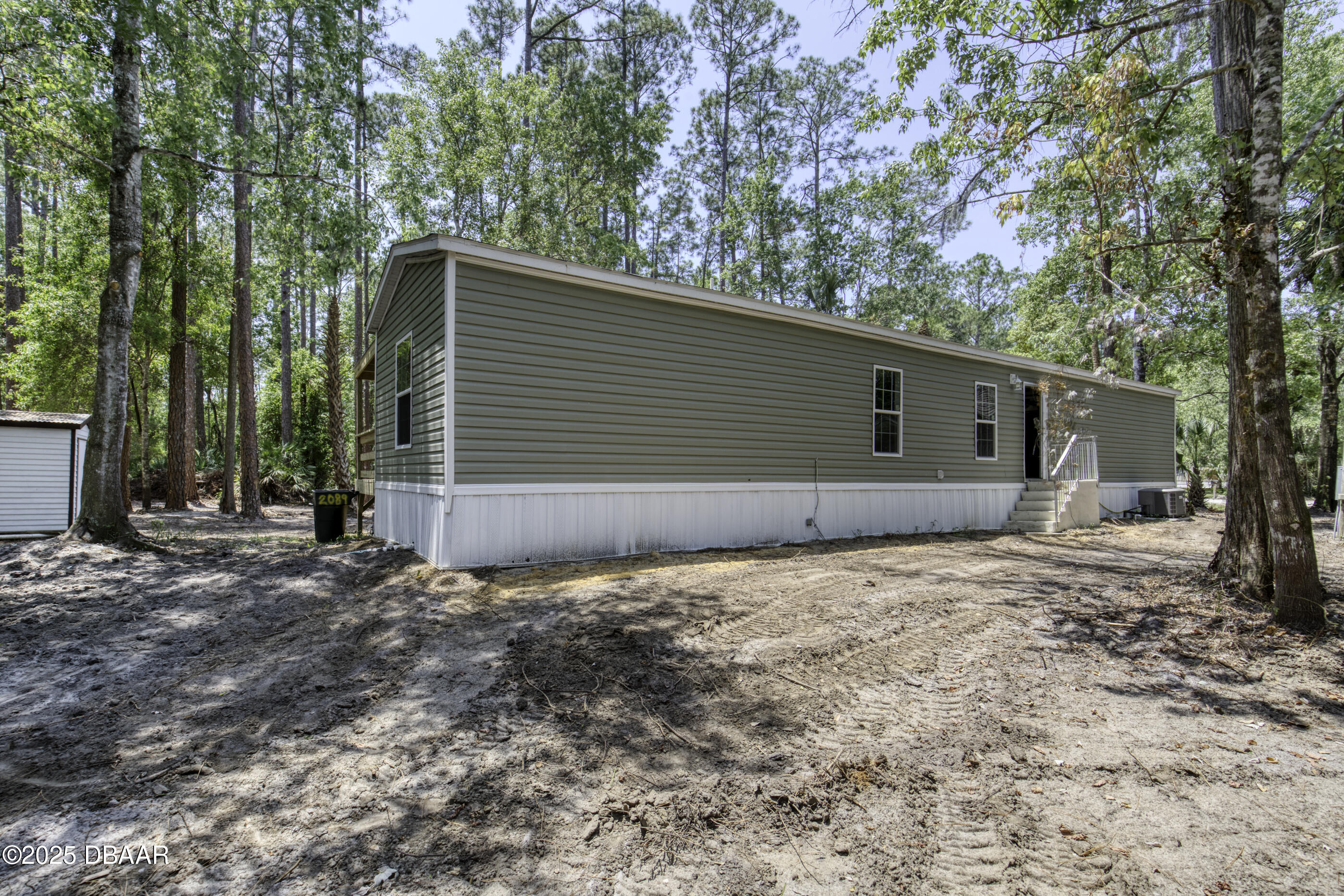 2089 Guava Lane Bunnell, FL 32110 - Photo 40 of 58 a backyard of a house with large trees and brick walls