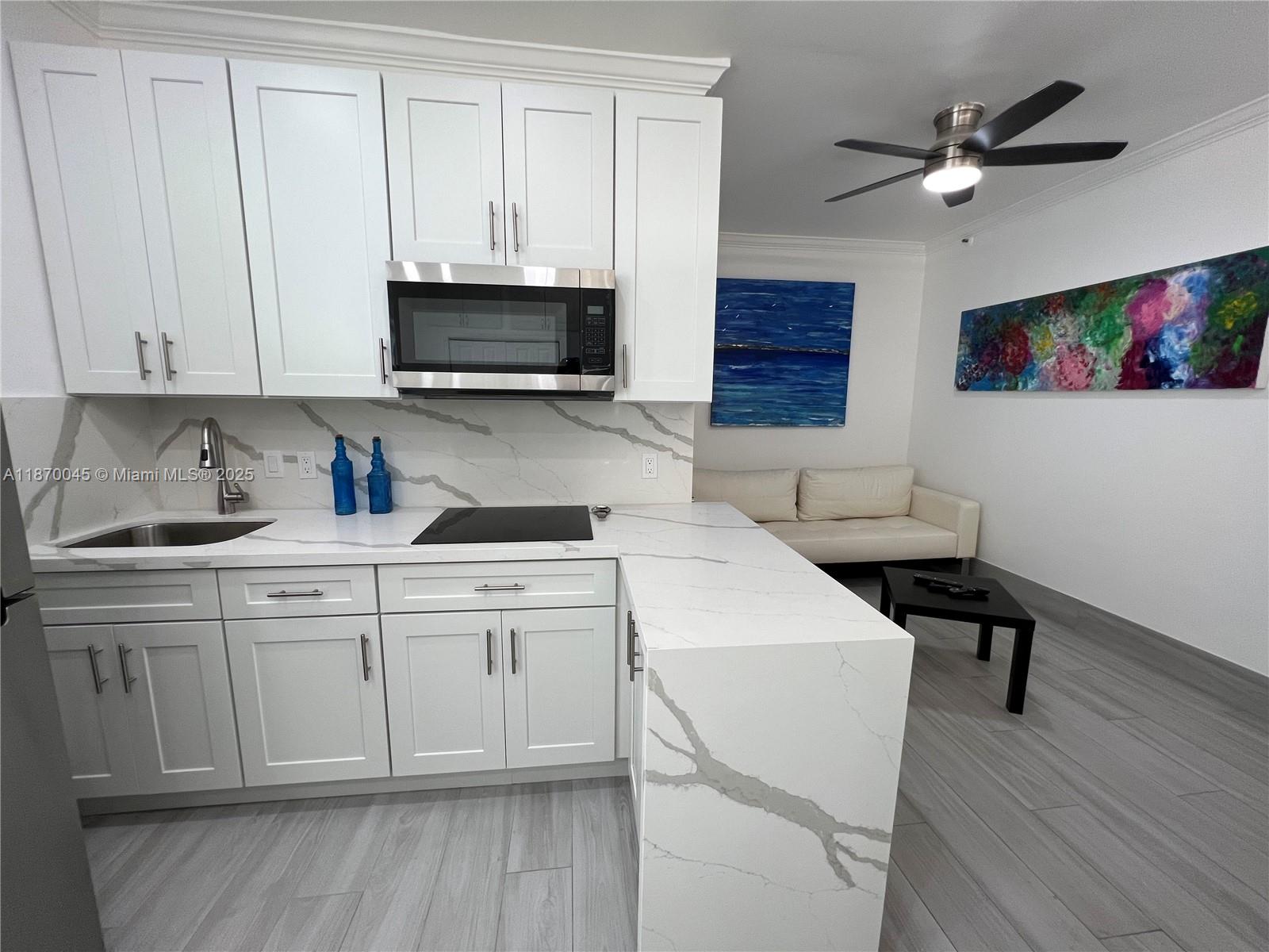 3710 Collins Avenue, Unit N103 Miami Beach, FL 33140 - Photo 13 of 53 a kitchen with a sink cabinets and wooden floor