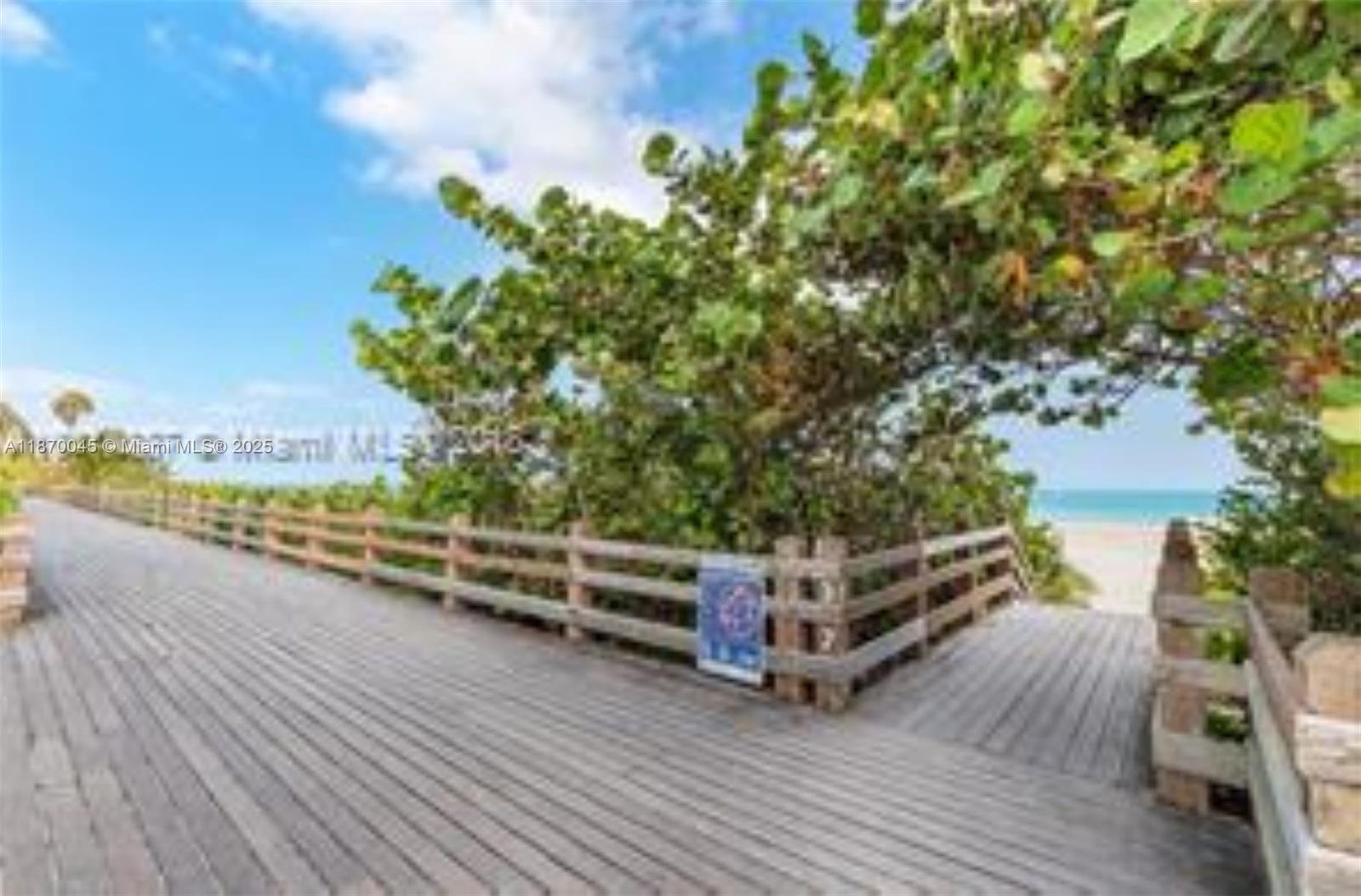 3710 Collins Avenue, Unit N103 Miami Beach, FL 33140 - Photo 20 of 53 a view of a wooden deck and trees in the background