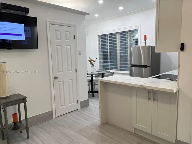 a kitchen with a refrigerator and a stove top oven