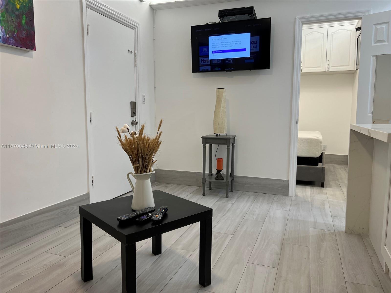 3710 Collins Avenue, Unit N103 Miami Beach, FL 33140 - Photo 5 of 53 a living room with furniture and a flat screen tv