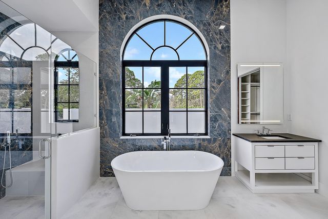 a view of spacious bathroom with a large tub and large window