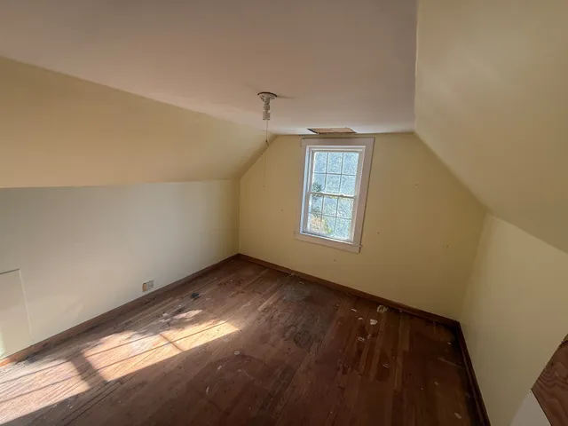 a large bedroom with a bed and a night stand