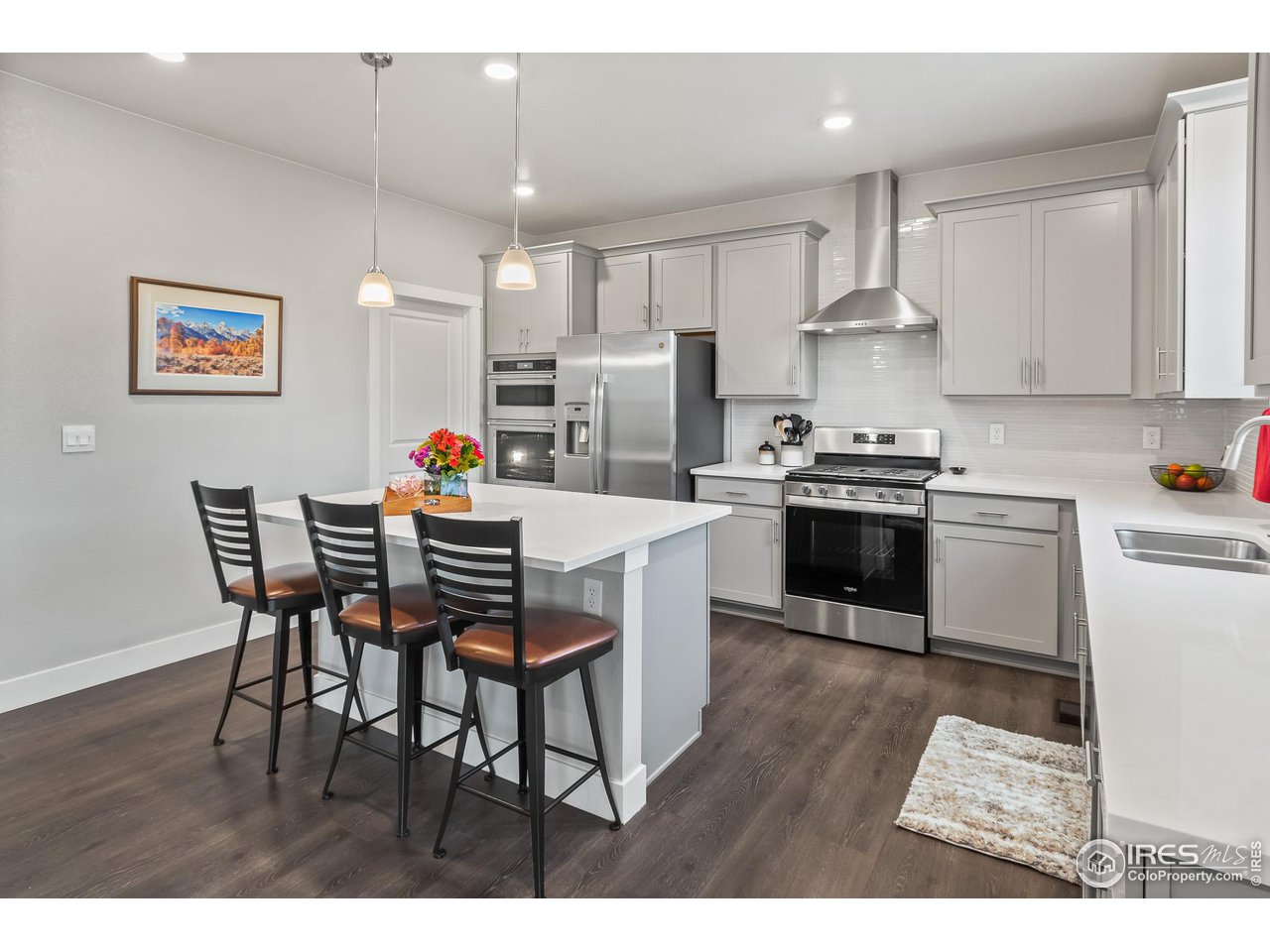 1687 Rivergate Way Berthoud, CO 80513 - Photo 21 of 39 a kitchen with stainless steel appliances a table chairs refrigerator and cabinets