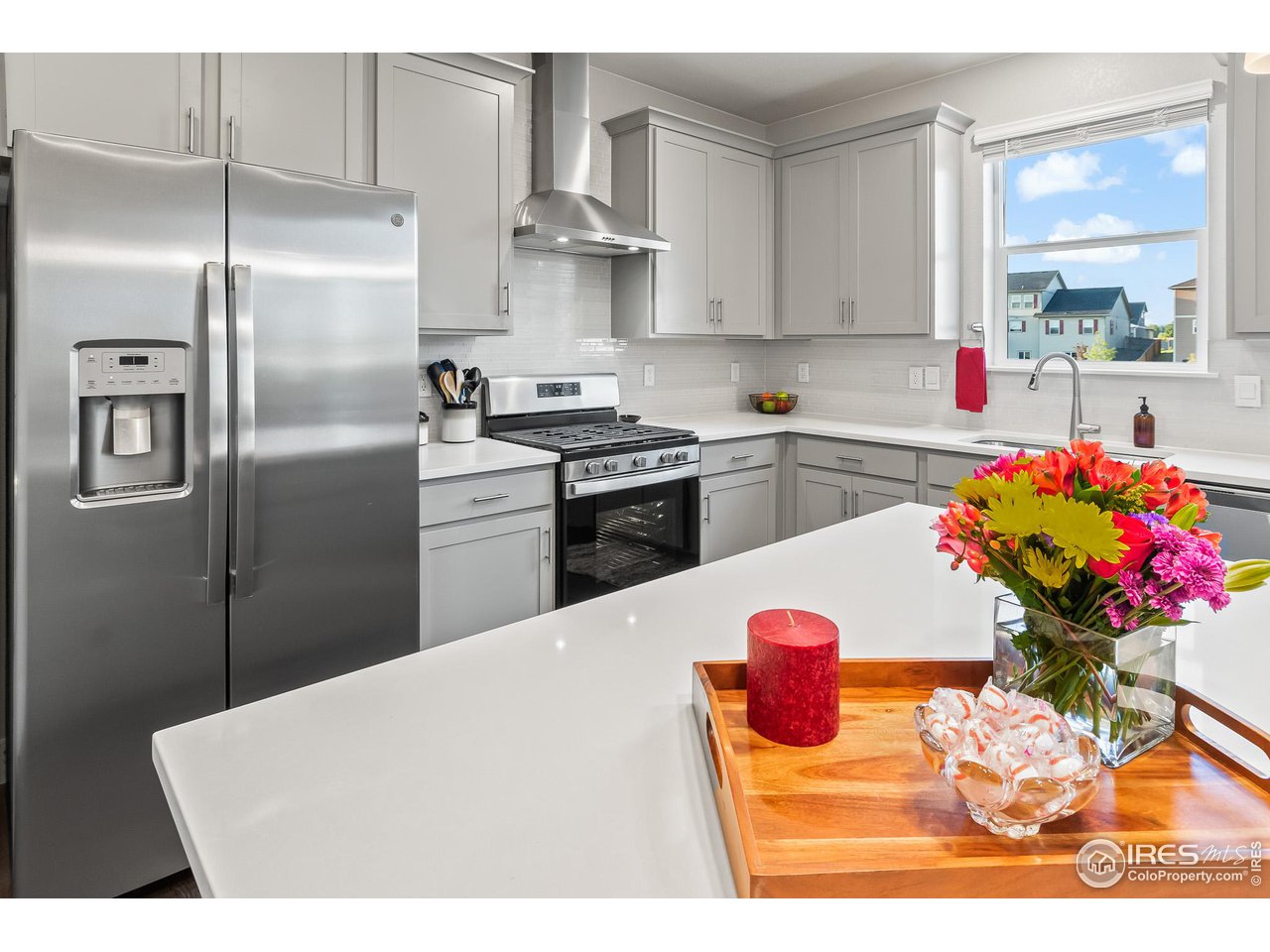 1687 Rivergate Way Berthoud, CO 80513 - Photo 24 of 39 a kitchen with stainless steel appliances kitchen island granite countertop a refrigerator a sink dishwasher and white cabinets with wooden floor