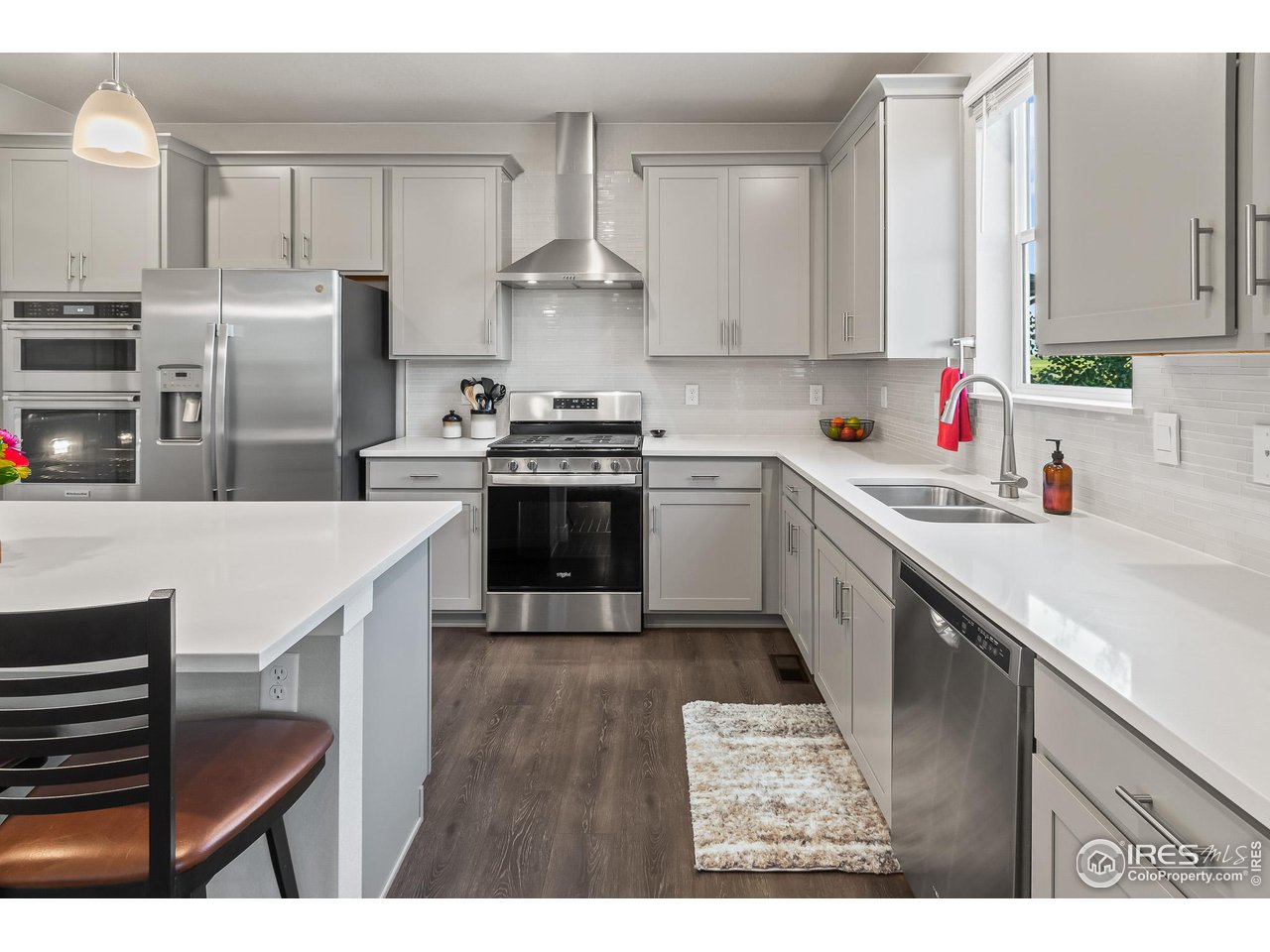 1687 Rivergate Way Berthoud, CO 80513 - Photo 26 of 39 a kitchen with stainless steel appliances a sink a stove a refrigerator and cabinets