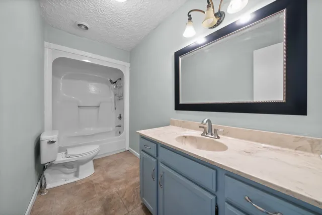 a bathroom with a toilet a sink a mirror and a bathtub
