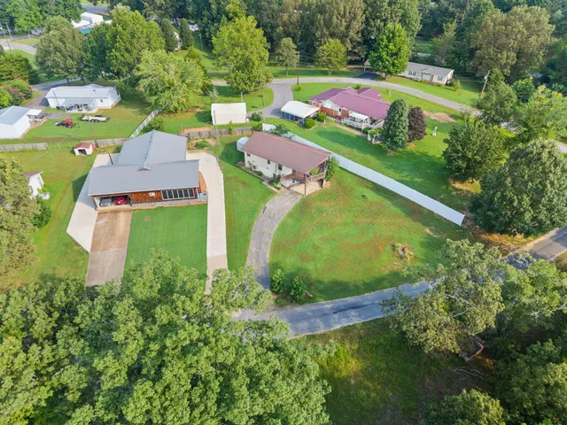 an aerial view of a house with a garden and swimming pool