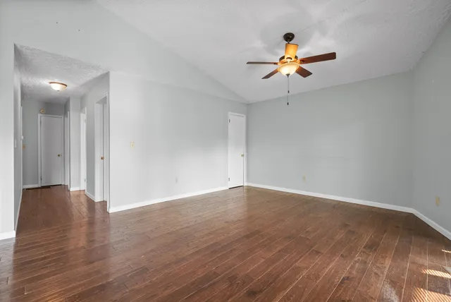 a view of a livingroom with a ceiling fan and wooden floor