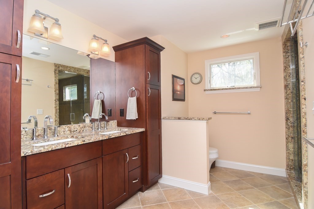 151 School Street Acton, MA 01720 - Photo 23 of 39 a bathroom with a sink a mirror a vanity and a shower
