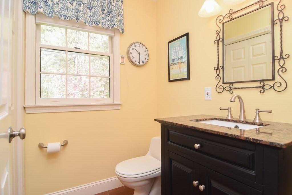 151 School Street Acton, MA 01720 - Photo 29 of 39 a bathroom with a granite countertop toilet a sink and a mirror