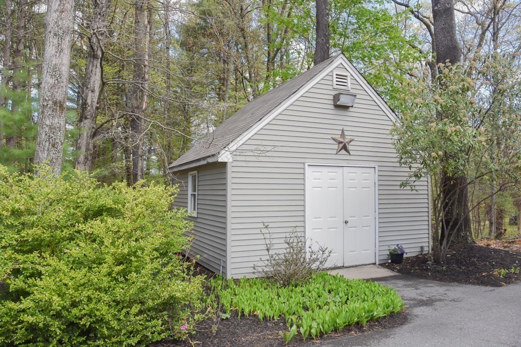 151 School Street Acton, MA 01720 - Photo 34 of 39 a view of a small house with a small yard and large trees