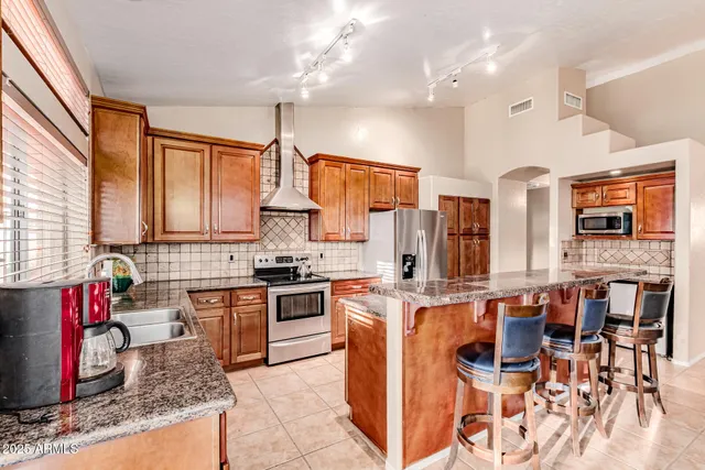 a kitchen with stainless steel appliances granite countertop a stove and a refrigerator