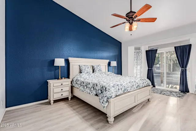 a bedroom with a bed chandelier and a window