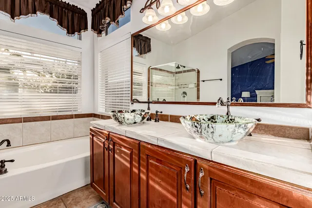 a bathroom with a granite countertop sink mirror and a bathtub