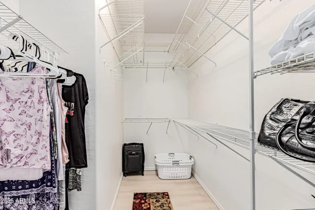 a view of walk in closet with clothes and shoes