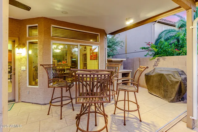 a patio with table and chairs and potted plants
