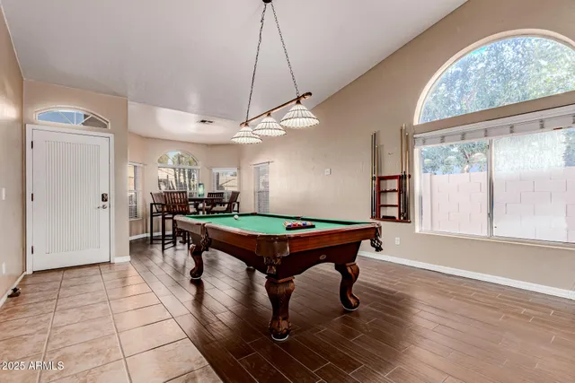 a room with pool table and windows