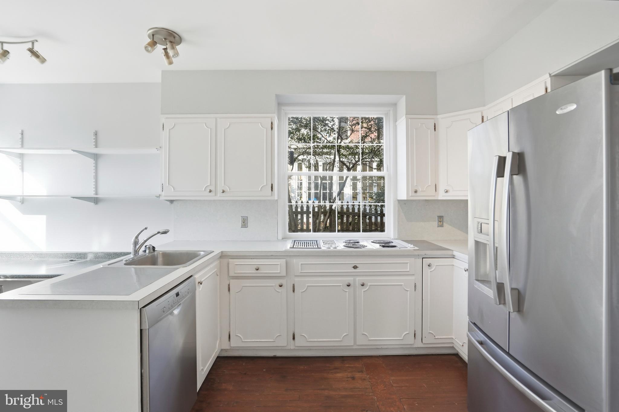 4416 Underwood Road Baltimore, MD 21218 - Photo 14 of 42 a kitchen with a sink cabinets stainless steel appliances and a window