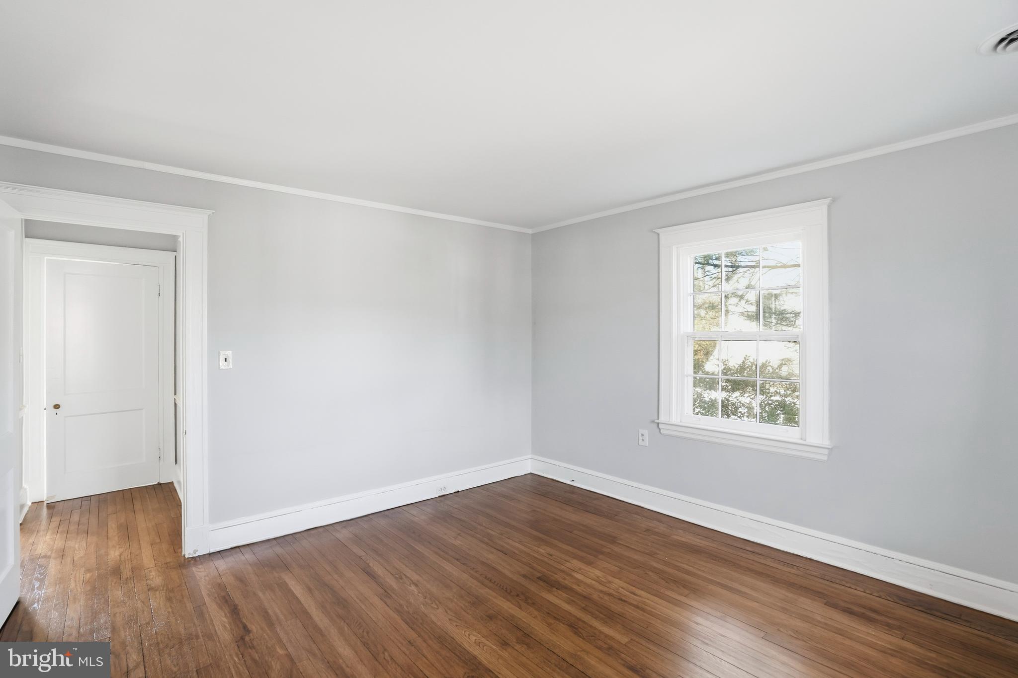 4416 Underwood Road Baltimore, MD 21218 - Photo 22 of 42 an empty room with wooden floor and windows