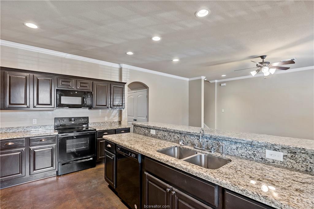4295 Commando Trail College Station, TX 77845 - Photo 13 of 25 a kitchen with stainless steel appliances granite countertop a sink and stove top oven