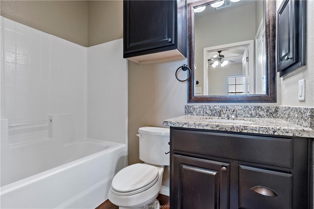4295 Commando Trail College Station, TX 77845 - Photo 16 of 25 a bathroom with a granite countertop sink toilet and shower