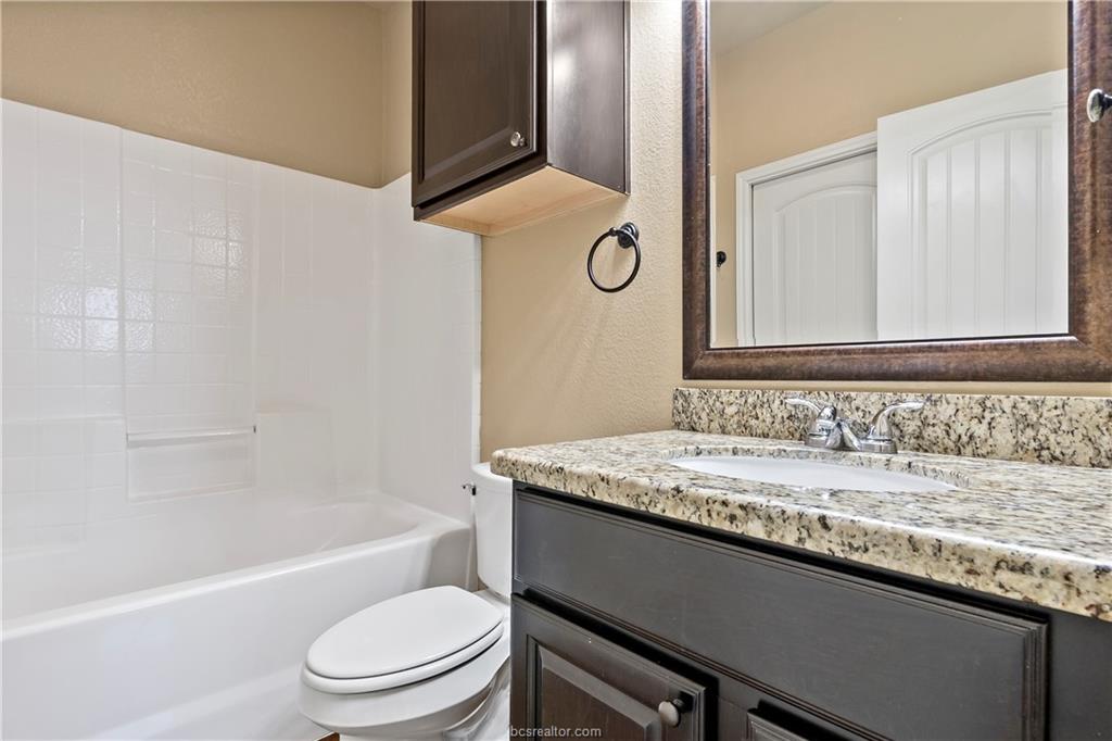 4295 Commando Trail College Station, TX 77845 - Photo 18 of 25 a bathroom with a granite countertop bathtub sink vanity mirror and toilet
