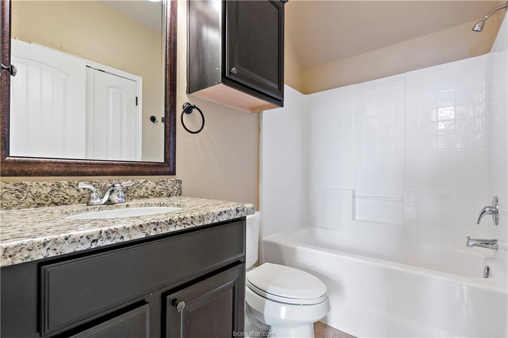 4295 Commando Trail College Station, TX 77845 - Photo 21 of 25 a bathroom with a granite countertop sink and a mirror