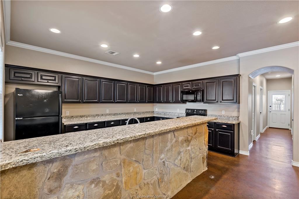4295 Commando Trail College Station, TX 77845 - Photo 9 of 25 a kitchen with stainless steel appliances granite countertop a stove a sink and a refrigerator