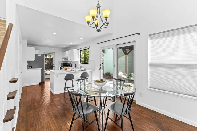 a view of a dining room with furniture a chandelier and wooden floor