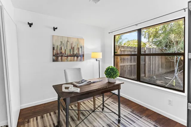 a view of a workspace with furniture and window