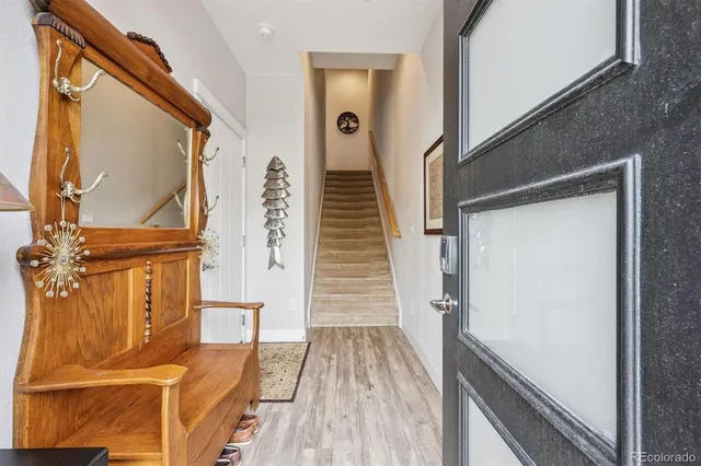 a view of a hallway with wooden floor and staircase