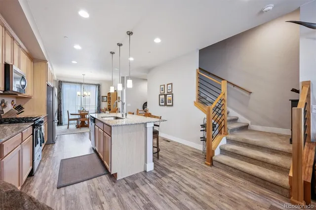 a kitchen with stainless steel appliances granite countertop a stove and a wooden floors