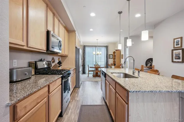 a kitchen with stainless steel appliances granite countertop a sink stove and cabinets