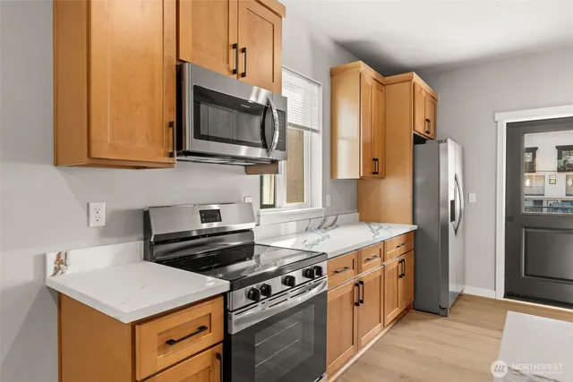 a kitchen with stainless steel appliances a stove a refrigerator a sink and cabinets