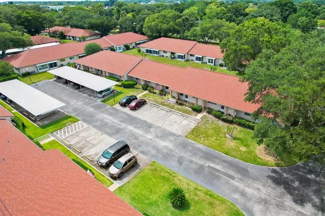 an aerial view of residential houses with outdoor space and trees