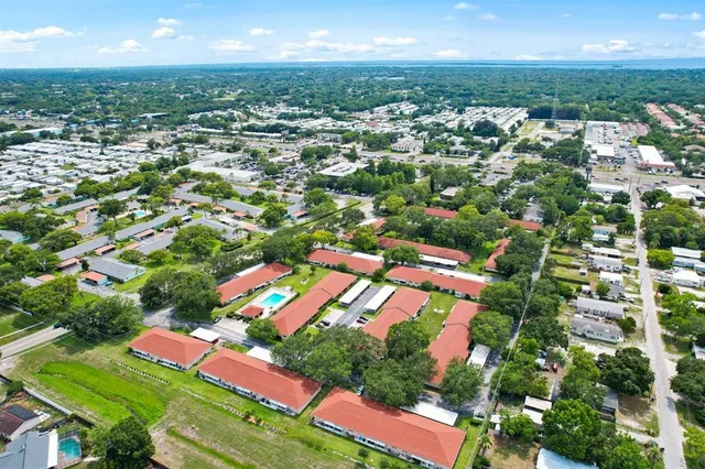 an aerial view of residential houses with outdoor space and swimming pool
